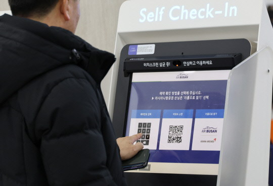 제주 기점 노선 항공편 운항이 재개된 24일 오전 제주국제공항 국내선 출발층에서 승객이 셀프 체크인을 하고 있다.  연합뉴스